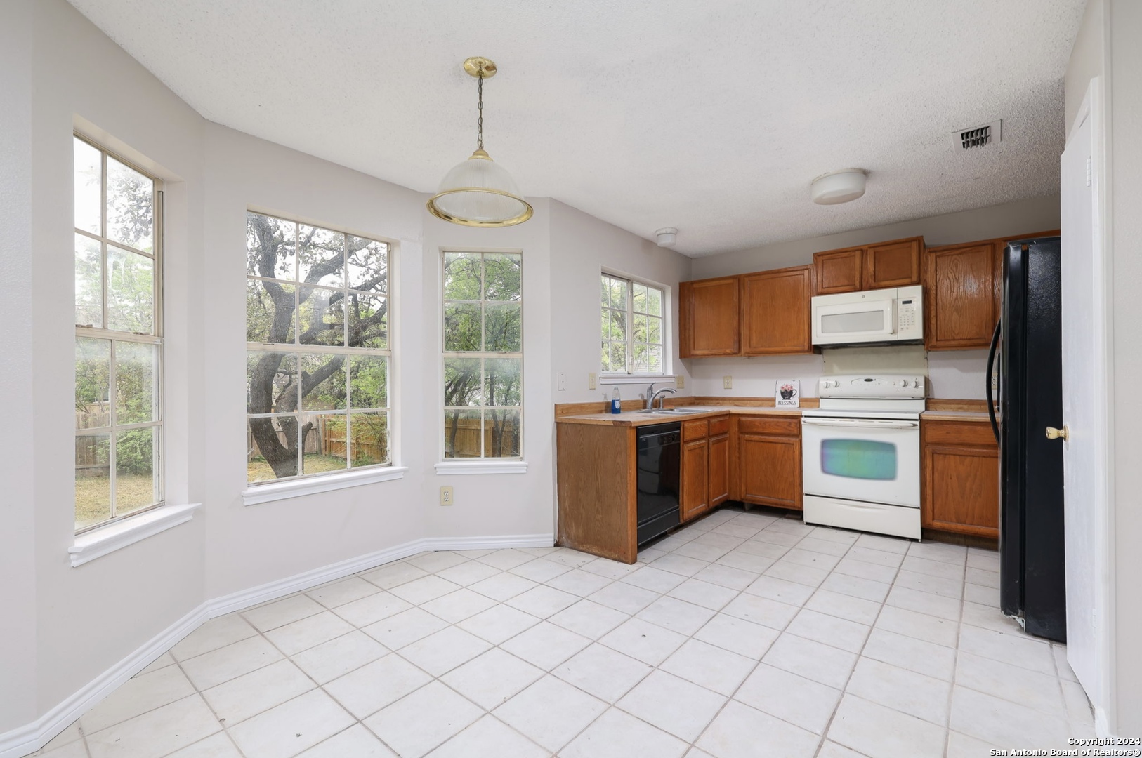 9159 Ridge Mill San Antonio, TX 78250 - Photo 8 of 17 a kitchen with stainless steel appliances kitchen island granite countertop a stove a sink and a refrigerator