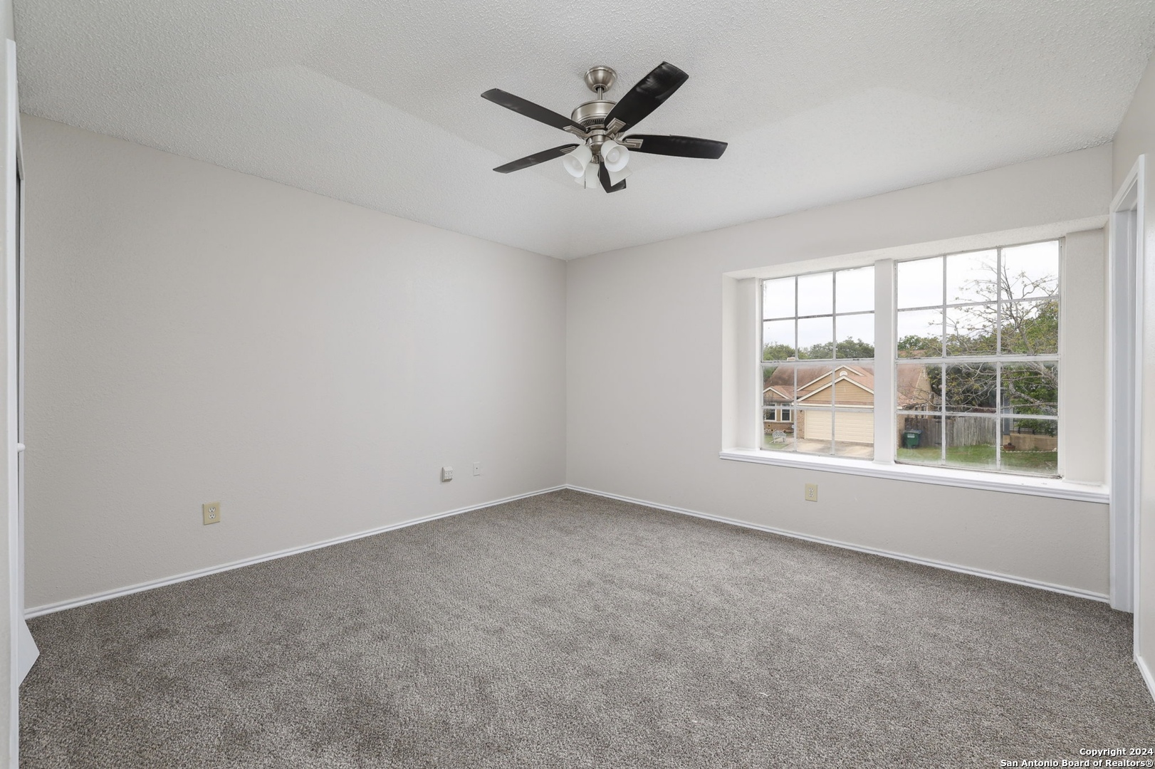 9159 Ridge Mill San Antonio, TX 78250 - Photo 10 of 17 an empty room with a ceiling fan and window
