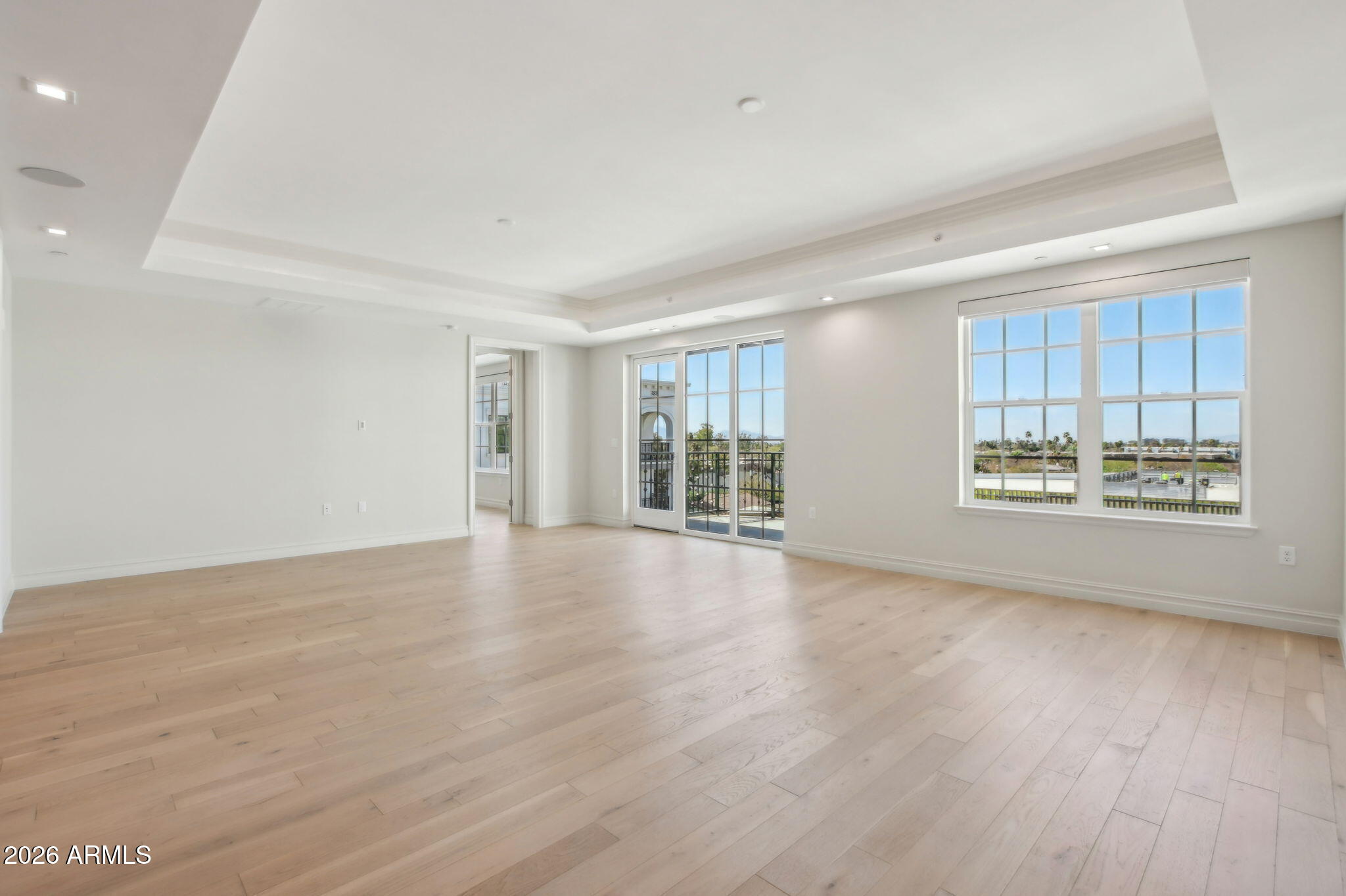 4240 East Camelback Road, Unit 514 Phoenix, AZ 85018 - Photo 5 of 16 a view of an empty room with a window and wooden floor