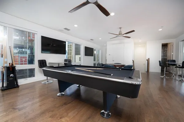 a living room with furniture pool table and a flat screen tv