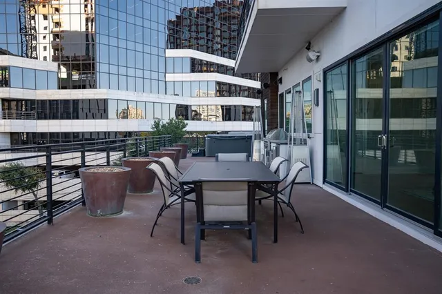 a patio with table and chairs and potted plants