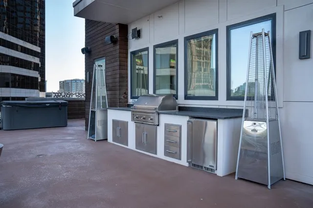 a view of a house with a barbeque and large windows