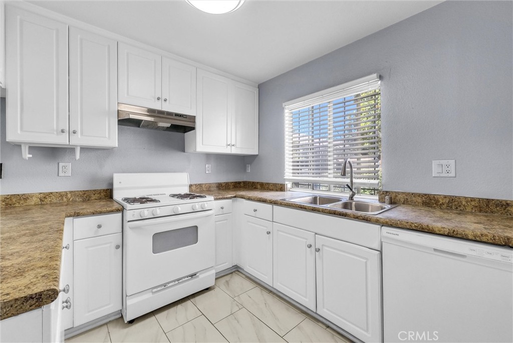 3738 Harrison Street, Unit 31 Riverside, CA 92503 - Photo 12 of 35 a kitchen with granite countertop white cabinets and white appliances