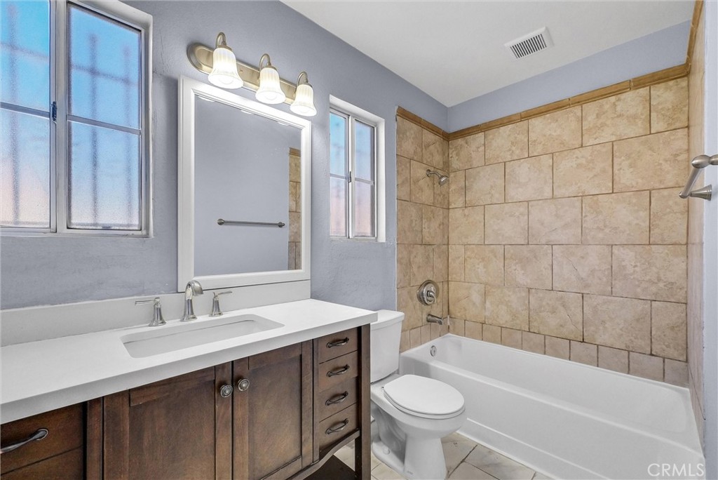 3738 Harrison Street, Unit 31 Riverside, CA 92503 - Photo 25 of 35 a bathroom with a sink a toilet a mirror a bathtub and shower