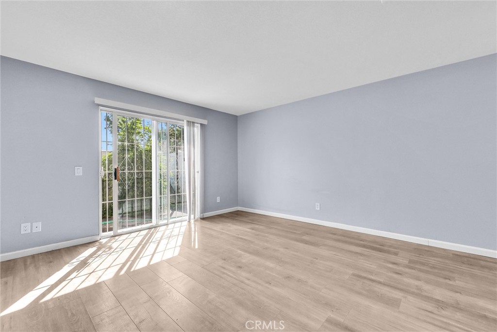 3738 Harrison Street, Unit 31 Riverside, CA 92503 - Photo 10 of 35 a view of an empty room with wooden floor and a window
