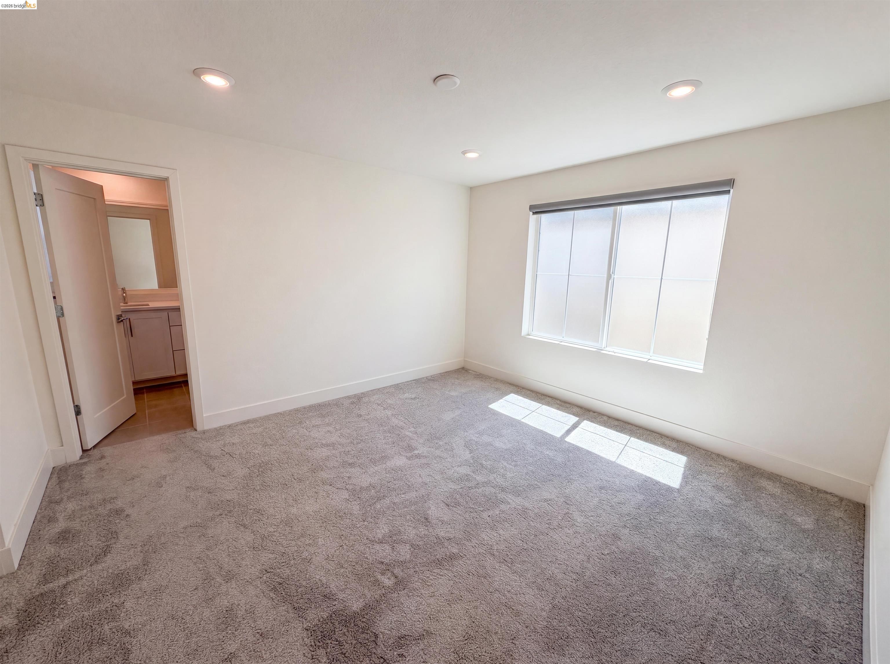 9034 Rudder Way Newark, CA 94560 - Photo 14 of 38 Carpeted room featuring a large window with roller shades, recessed lighting, and a white baseboard trim