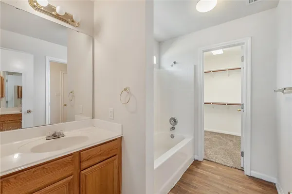 a bathroom with a tub sink double vanity and tub
