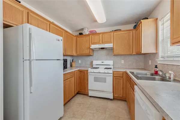 a kitchen with stainless steel appliances white cabinets and a refrigerator