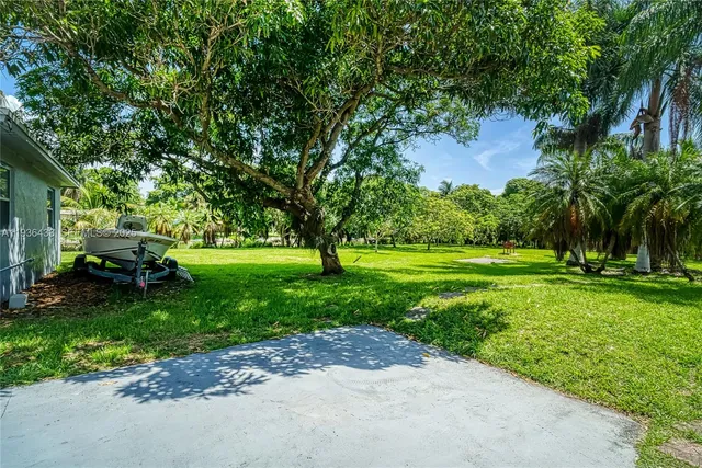an aerial view of residential houses with outdoor space and trees