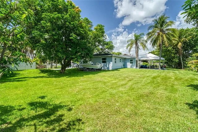 an aerial view of residential houses with outdoor space and lake view