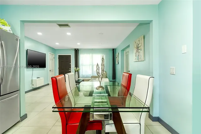 a living room with furniture and a dining table with bookshelf