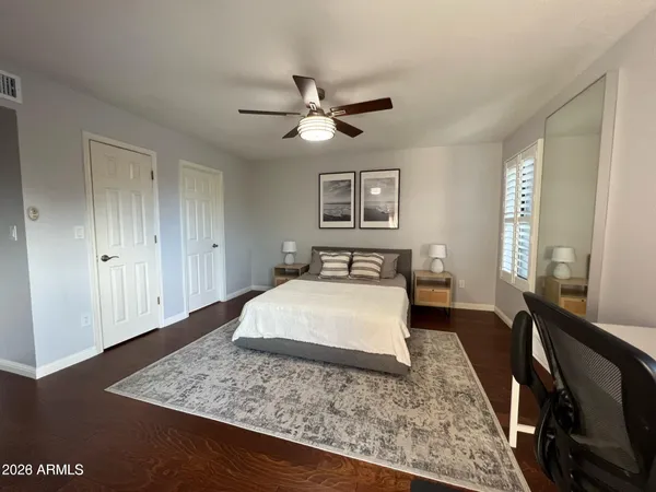 a bedroom with a large bed and wooden floor