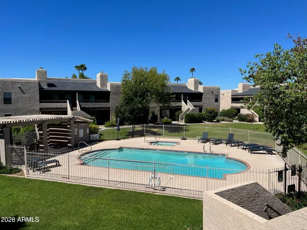 a view of a house with pool and chairs