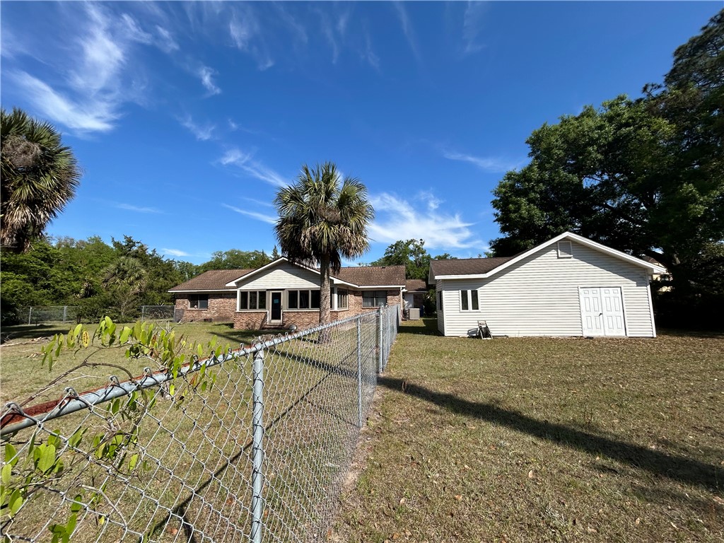103 Cartwright Circle Brunswick, GA 31525 - Photo 3 of 5 Back of home with glassed in porch, and detached 2 car garage.