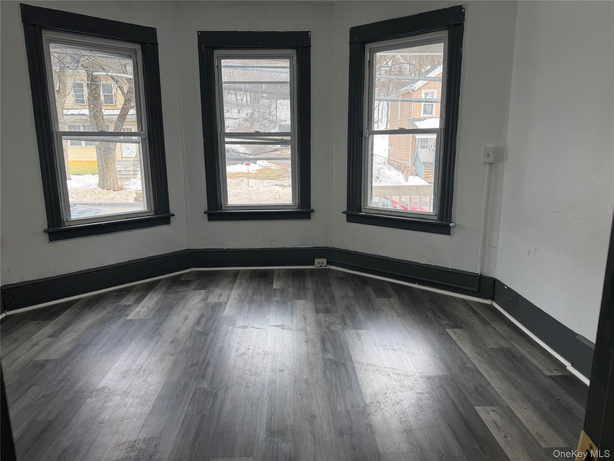 210 North Hamilton Street, Unit 1 Poughkeepsie, NY 12601 - Photo 5 of 15 an empty room with wooden floor and windows