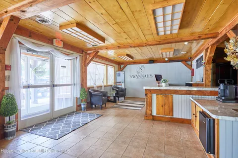 a living room with furniture a wooden floor and next to a window
