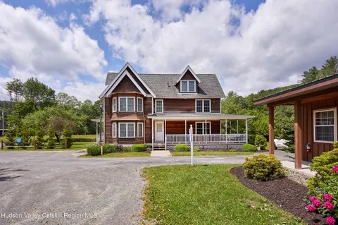 a front view of a house with a yard and trees