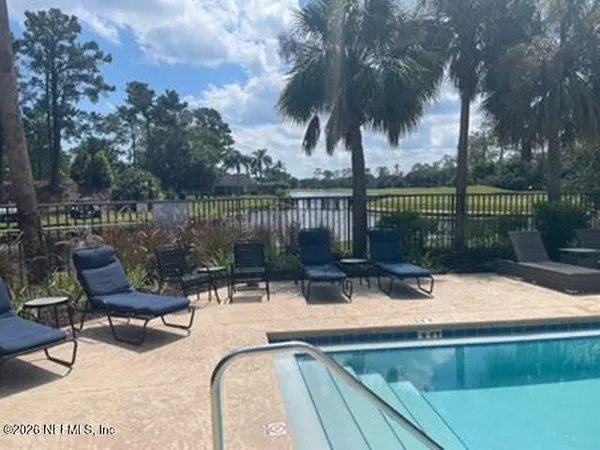 a view of a lake with couches and wooden fence