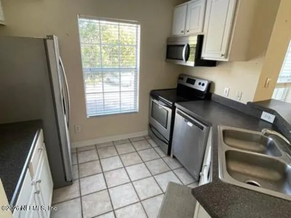 a kitchen with stainless steel appliances a sink a stove a microwave and a counter top