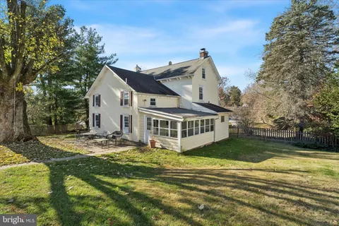 a view of a house with backyard and trees