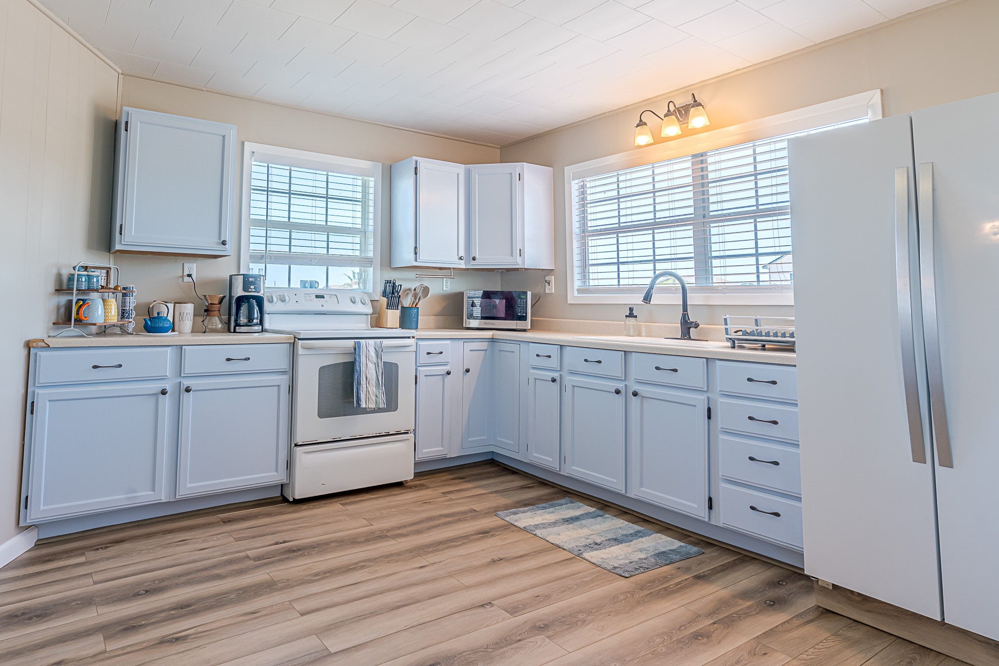 402 Seashell Drive Surfside Beach, TX 77541 - Photo 12 of 35 a kitchen with white cabinets sink and window
