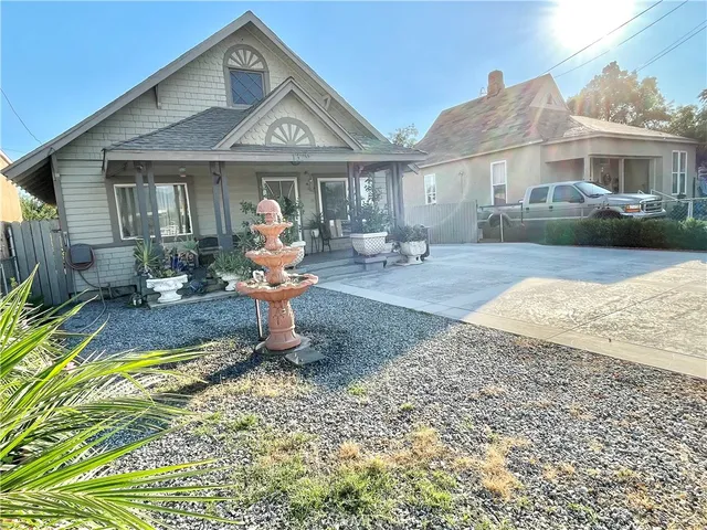 a front view of a house with swimming pool and furniture