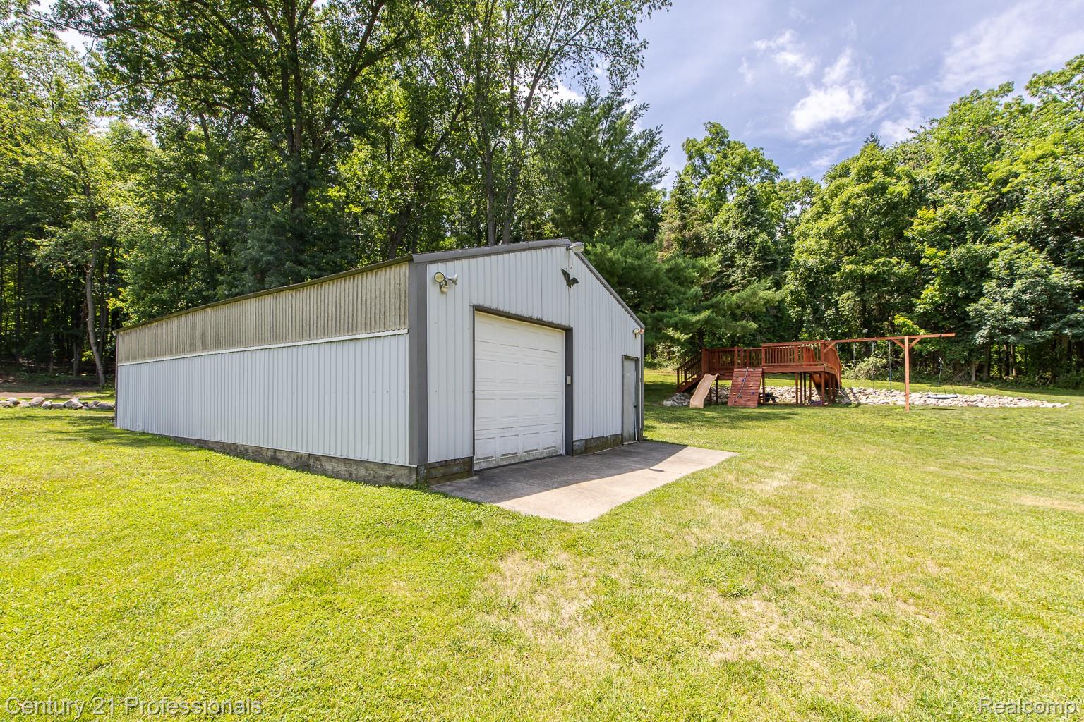 1790 Kent Road Ortonville, MI 48462 - Photo 41 of 64 Large metal outbuilding with a roll-up garage door and an additional entry door