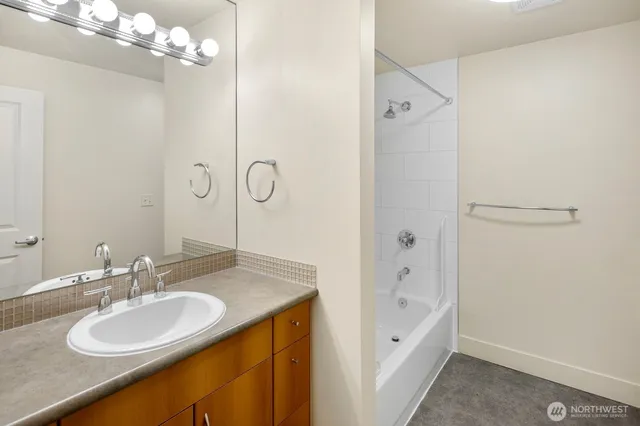 a bathroom with a granite countertop sink a shower and a mirror