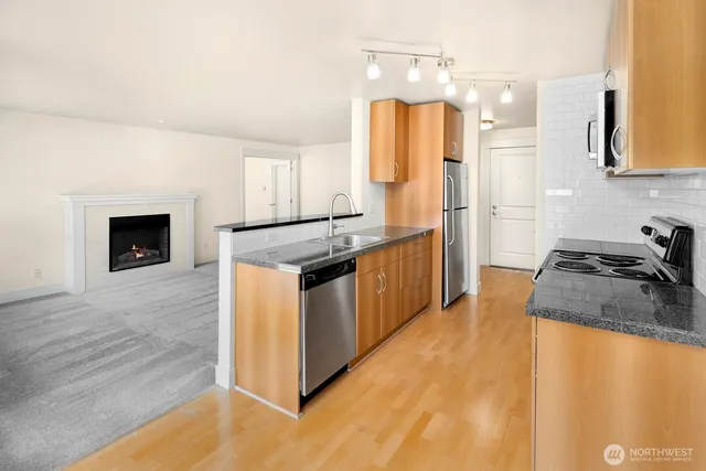 a kitchen with stainless steel appliances granite countertop a stove a sink and a refrigerator