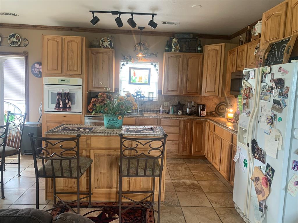 1980 Compass Way Bluff Dale, TX 76433 - Photo 10 of 16 a kitchen with stainless steel appliances a sink and a refrigerator