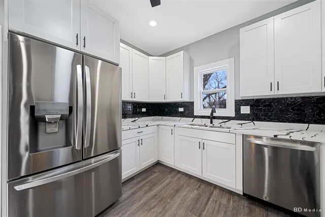 a kitchen with stainless steel appliances a refrigerator sink and cabinets