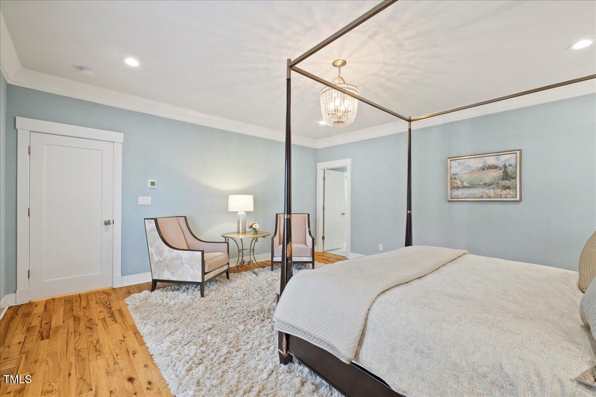 2605 Ridge Road Raleigh, NC 27612 - Photo 26 of 51 a spacious bedroom with a bed and painting on the wall