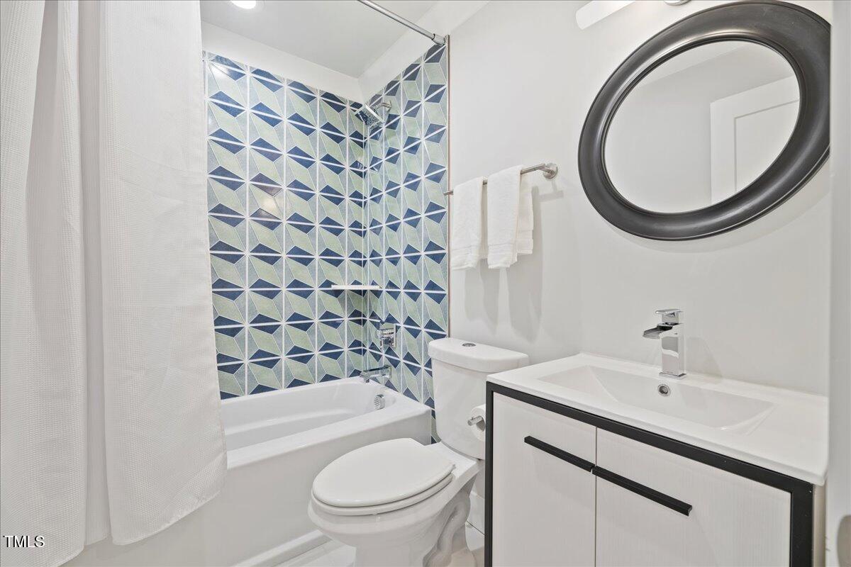 2605 Ridge Road Raleigh, NC 27612 - Photo 36 of 51 a bathroom with a sink a toilet and a mirror