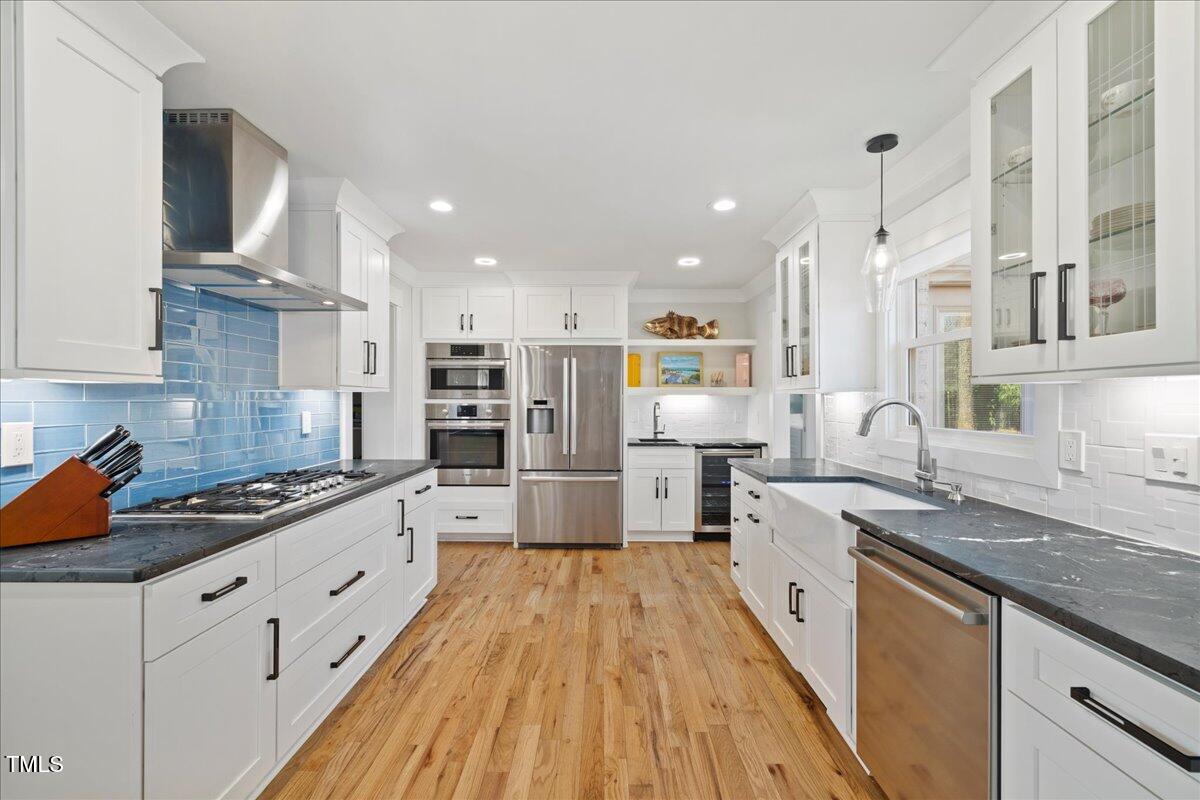 2605 Ridge Road Raleigh, NC 27612 - Photo 9 of 51 a large kitchen with stainless steel appliances granite countertop a lot of counter space and wooden floors