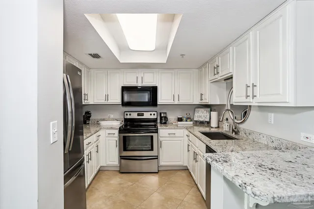 a kitchen with stainless steel appliances a refrigerator sink and stove top oven