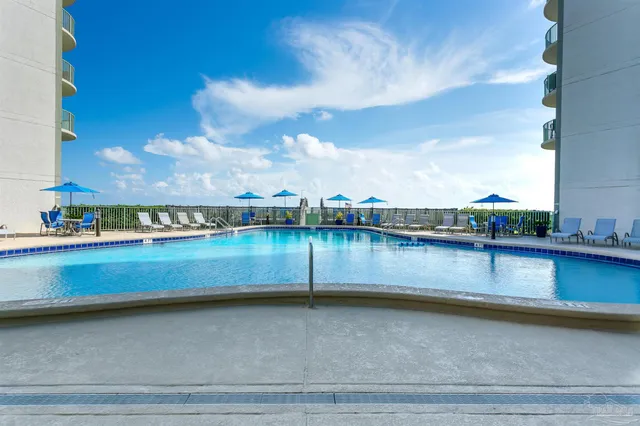 a balcony with wooden floor table and chairs