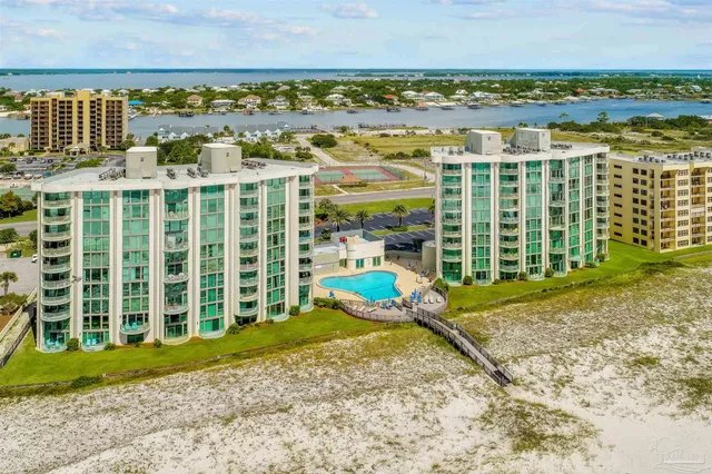 a view of swimming pool with lawn chairs and potted plants