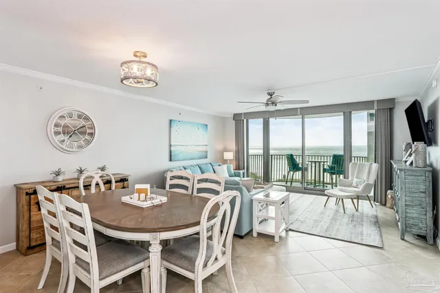 a view of a dining room with furniture a chandelier and a large window