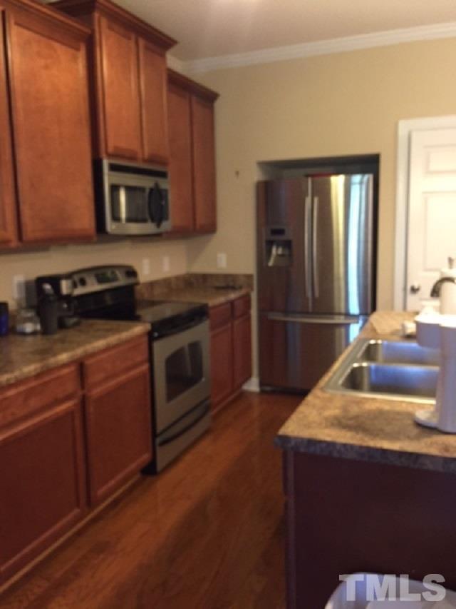 2013 Fieldhouse Avenue Raleigh, NC 27603 - Photo 2 of 4 a kitchen with kitchen island granite countertop wooden cabinets and a stove top oven