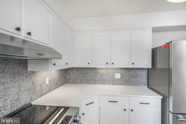 a kitchen with white cabinets and white appliances