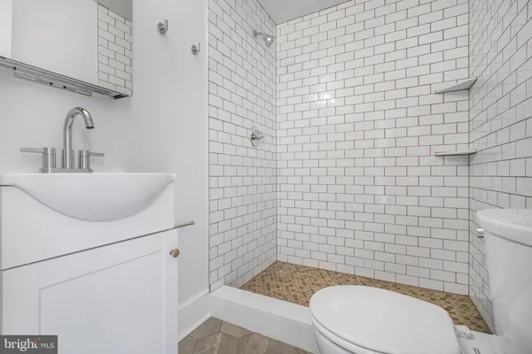 a bathroom with a sink a toilet and a mirror