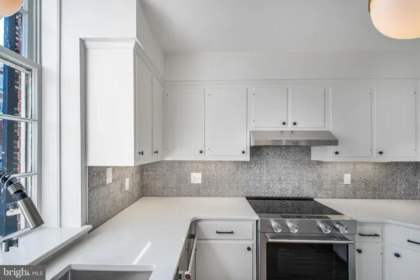 a kitchen with a sink stove and cabinets