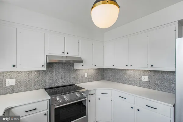 a kitchen with white cabinets and white appliances