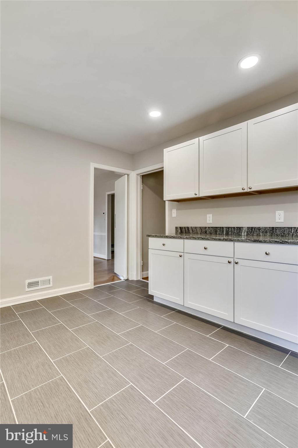 3303 Winnett Road Chevy Chase, MD 20815 - Photo 11 of 54 a spacious bathroom with a granite countertop sink and a mirror