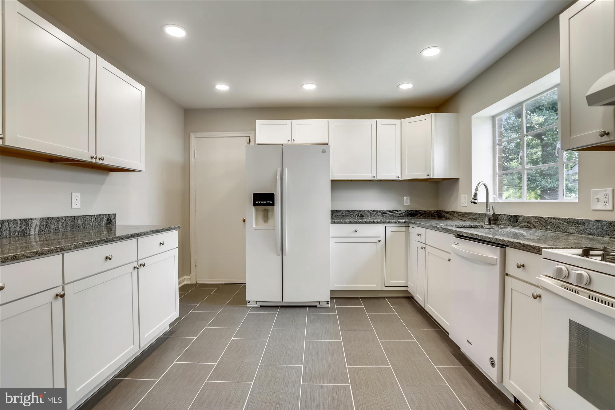 3303 Winnett Road Chevy Chase, MD 20815 - Photo 4 of 54 a kitchen with granite countertop white cabinets and white appliances