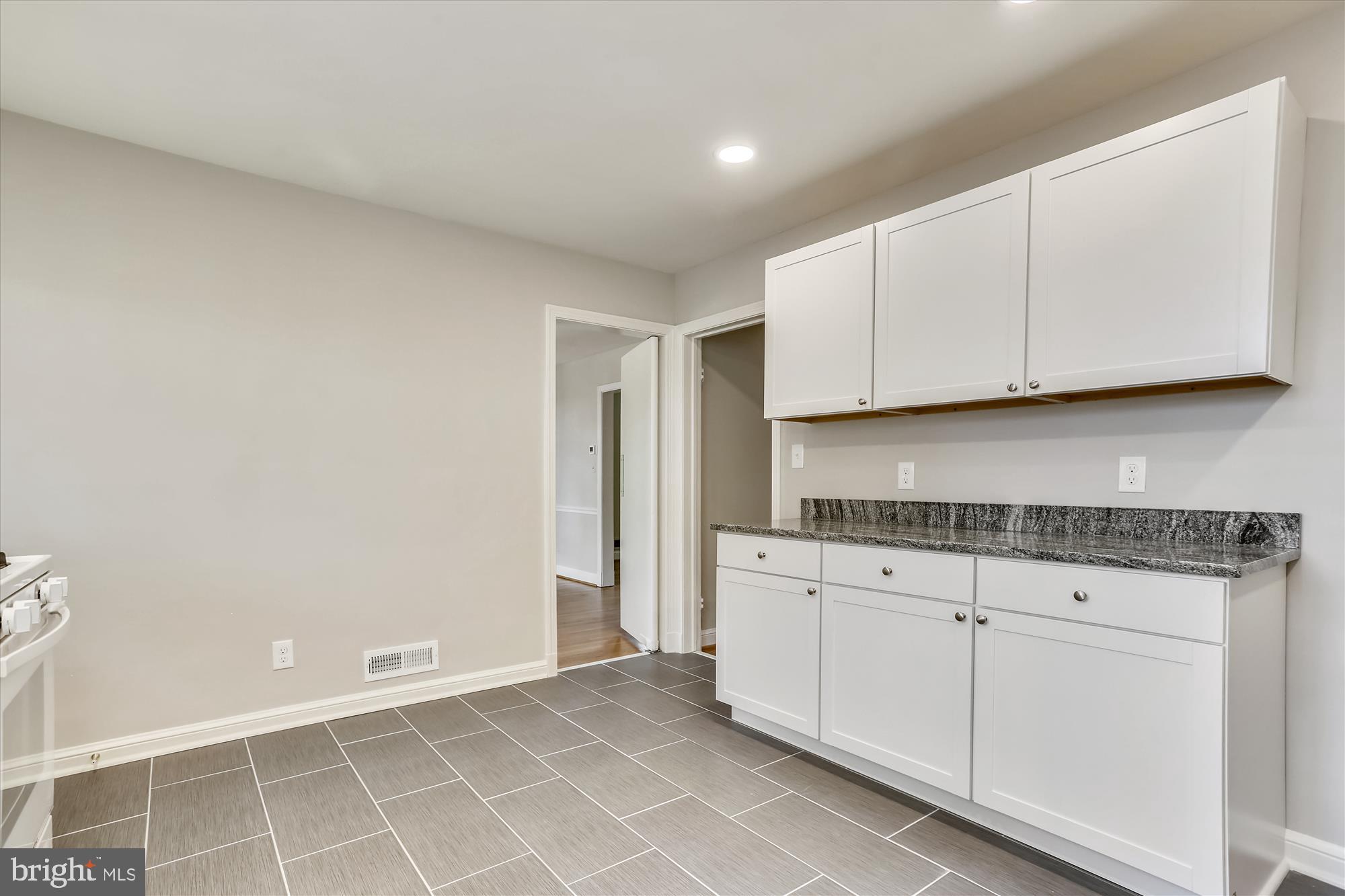 3303 Winnett Road Chevy Chase, MD 20815 - Photo 8 of 54 a kitchen with granite countertop white cabinets and a sink