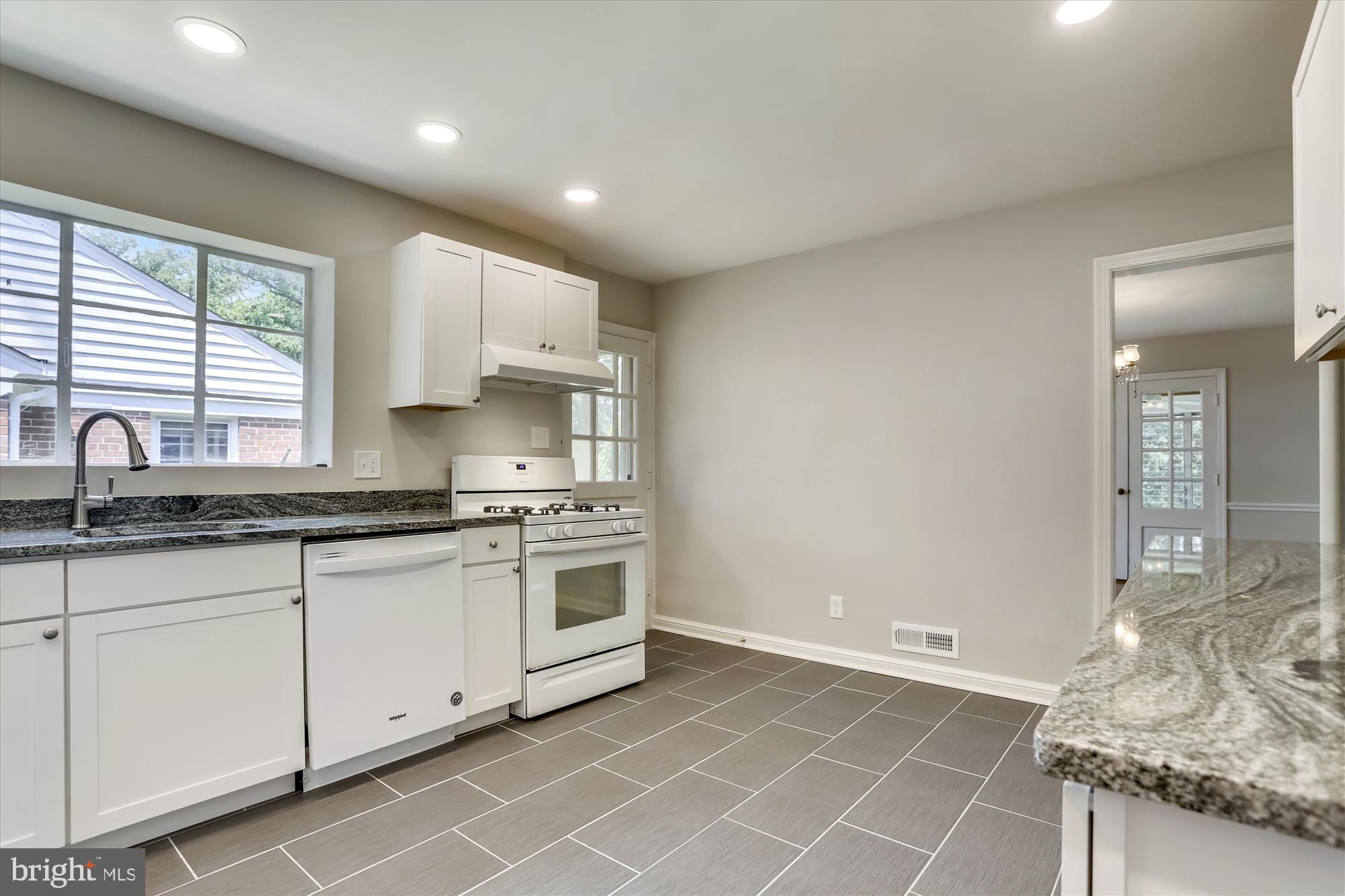 3303 Winnett Road Chevy Chase, MD 20815 - Photo 9 of 54 a kitchen with granite countertop white cabinets and white appliances