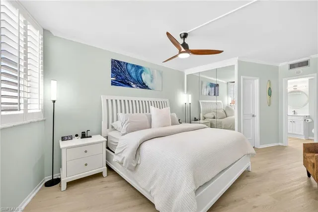 a spacious bedroom with a bed and a chandelier