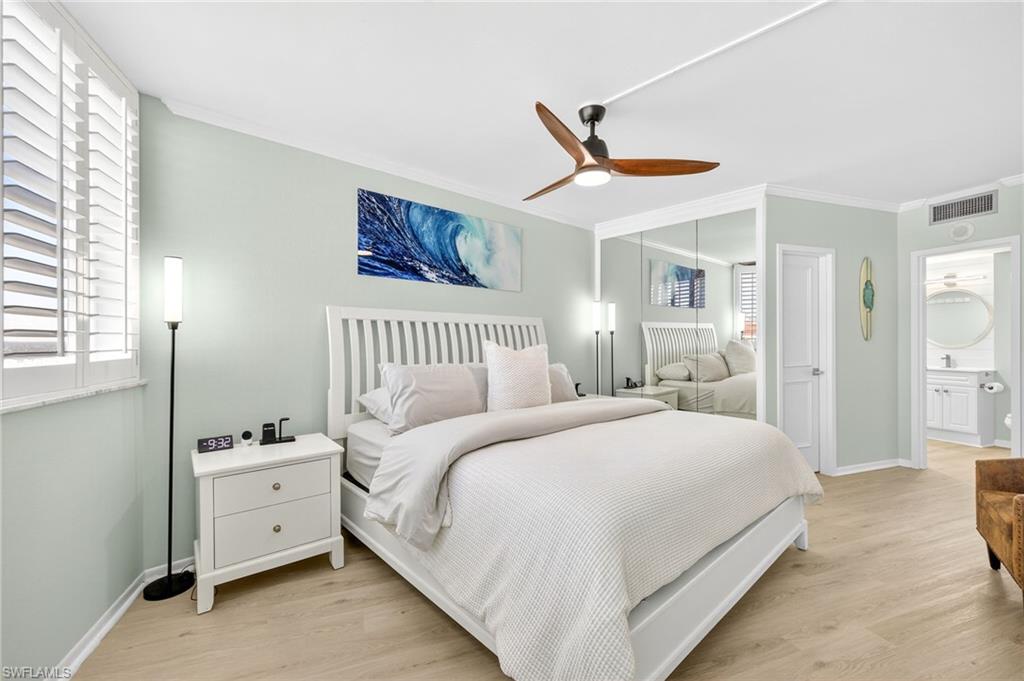 58 North Collier Boulevard, Unit 1606 Marco Island, FL 34145 - Photo 12 of 37 a spacious bedroom with a bed and a chandelier