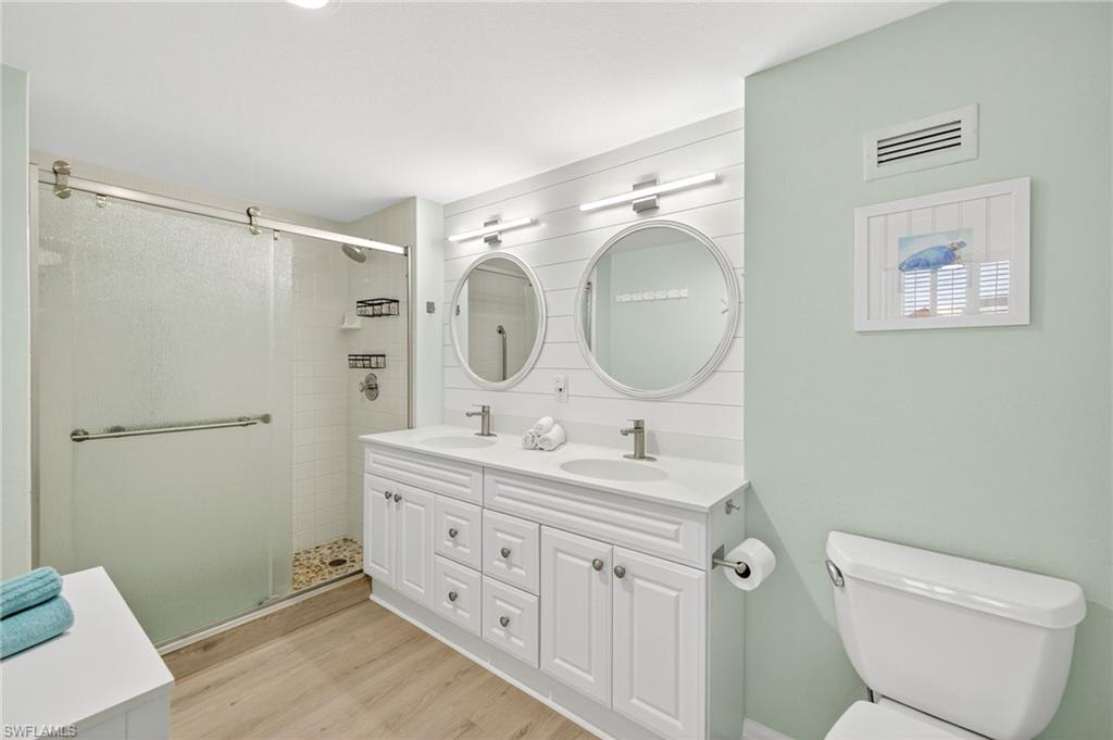 58 North Collier Boulevard, Unit 1606 Marco Island, FL 34145 - Photo 16 of 37 a bathroom with 2 sink toilet and a mirror